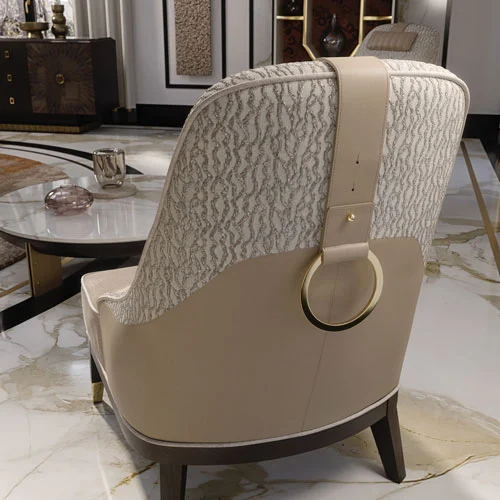 A close view of the armchair backrest, featuring a beige leather belt with an ornamental gold plated ring handle.